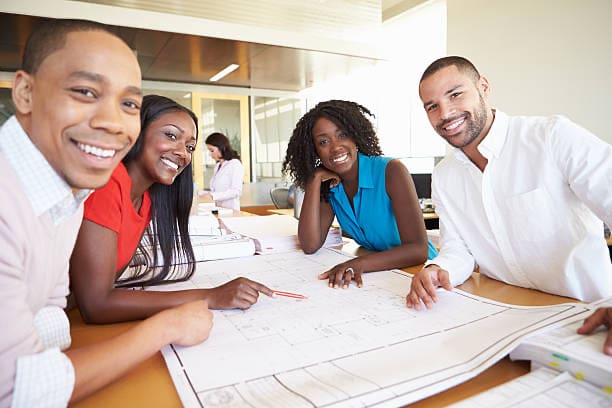 A group of people sitting at a table with papers.